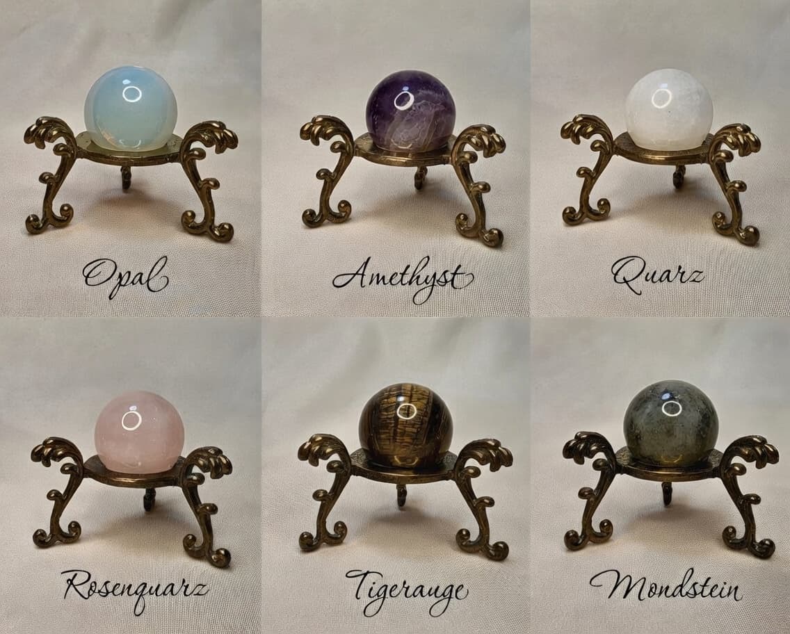 Alle sechs Momentemurmel-Steine auf goldenen Ständern: Opal, Amethyst, Quarz, Rosenquarz, Tigerauge, Mondstein